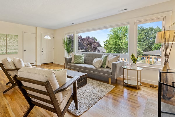 a classic contemporary lounge room with a modern grey sofa and two white cushion chairs