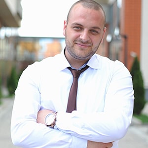 a white man wearing a white shirt and brown tie,cleanly shaved